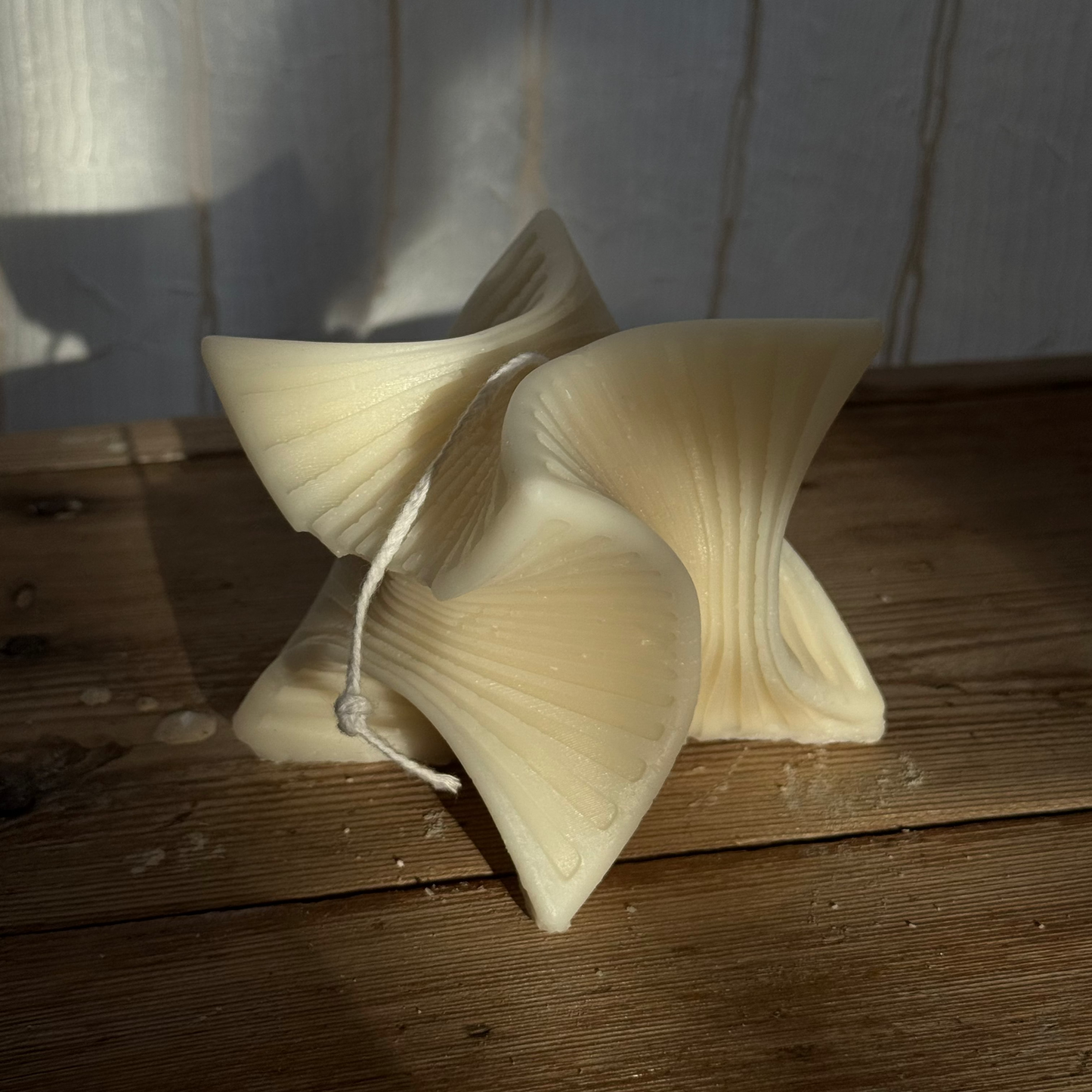 Decorative mushroom-shaped candle on a wooden surface with a neutral background